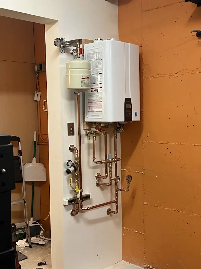Plumbing technician inspecting water heater connections in Lindon